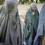 40483124_an_afghan_woman_clad_in_burqa_veil_begs_w